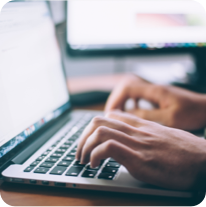 Hands typing on a laptop computer keyboard